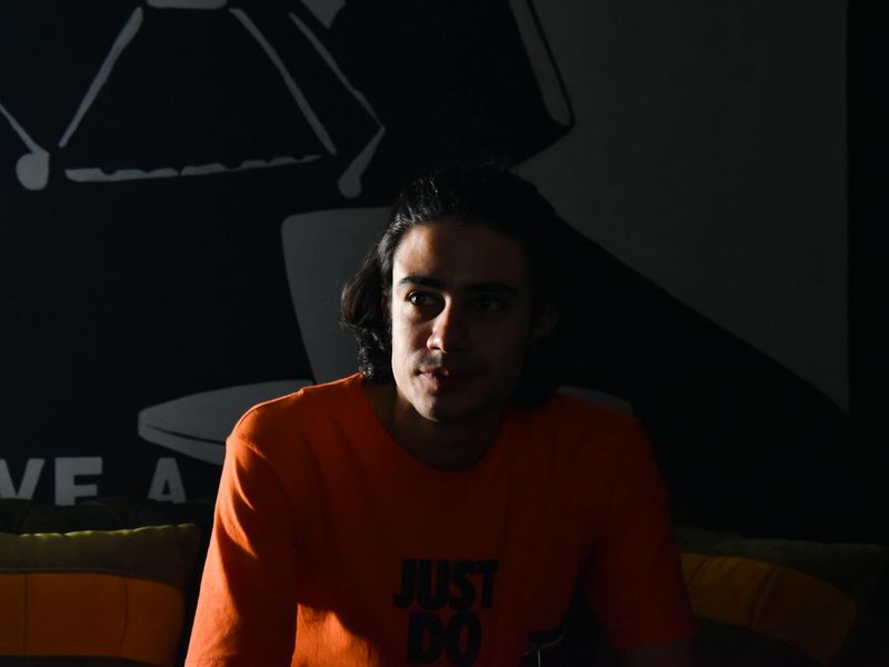 Person doing a deep stretch in a bright studio.